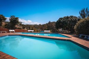 two swimming pools with blue water in a yard at tiki tides in Umdloti