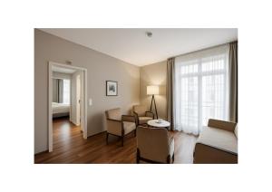a living room with a couch and chairs in a room at GLANDON Rooms Elite in Biel