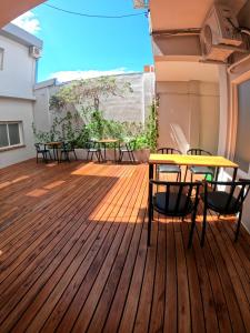 a deck with tables and chairs on a building at LakeHouse Hotel & Suites in Villa Carlos Paz