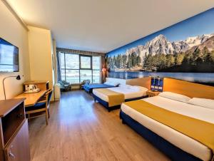 a hotel room with two beds and a painting on the wall at Hotel Express Aosta East in Aosta +59 photos