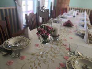 a long table with plates and a vase of flowers on it at POD ORŁEM in Wałcz