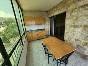 a kitchen with a wooden table and chairs in a room at HighLand Hotel in Aley