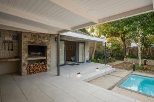 a patio with a swimming pool and a house at Ocean Breeze by The Oyster Collection in Kenton on Sea