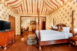 a bedroom with a bed and a flat screen tv at Rajasthali Resort & Spa in Jaipur