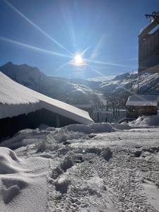 a snow covered slope with the sun in the background at Mountain air in Saint-Jean-dʼArves +2 photos