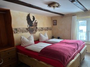 ein Schlafzimmer mit einem Bett mit einer roten Decke in der Unterkunft Western-Inn in Klipphausen