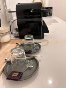 two glasses on a plate on a counter with a toaster at בצל האורן Betzel haoren in El-Rom