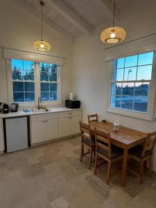 a kitchen with a wooden table and some windows at בצל האורן Betzel haoren in El-Rom