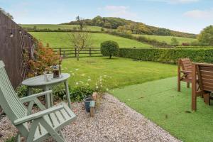 a garden with two benches and a table and a fence at 2 Bed in Brecon oc-r33603 in Lower Chapel