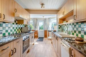 a kitchen with wooden cabinets and a stove top oven at 3 Bed in Portinscale oc-w31059 in Portinscale