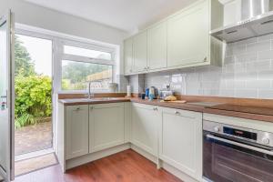 a kitchen with white cabinets and a window at 2 Bed in Mumbles oc-d32021 in The Mumbles +10 photos