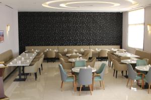 a dining room with tables and chairs and a chalkboard at H Luxury Hotel in Wadi Musa +52 photos