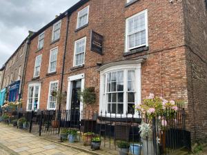 a brick building with white windows and flowers in front at The Castle House in Richmond