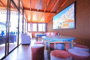 a room with a table and chairs and a large screen at Hotel Parador in Chefchaouen