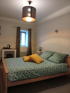 a bedroom with a bed with a green comforter at Hôtel de l'abbaye in Saint-Savin
