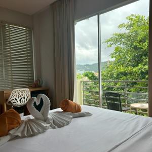 a bedroom with a bed with a large window at Casa De Coral Boutique Hotel in Kata Beach