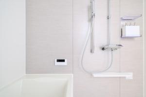 a white bathroom with a shower and a sink at Hakuba Caesar in Hakuba +70 photos