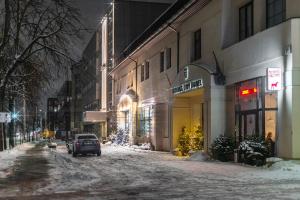a car parked on a snow covered street at night at Vilnius City Hotel in Vilnius