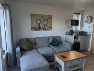 a living room with a couch and a table at Inverness Ardtower Escapes in Culloden +6 photos