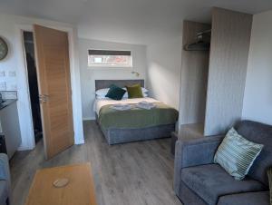 a bedroom with a bed and a couch and a chair at Inverness Ardtower Escapes in Culloden