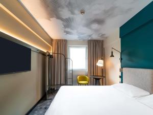 a hotel room with a bed and a yellow chair at Ibis Praha Wenceslas Square in Prague +51 photos
