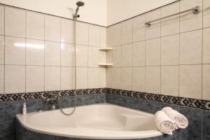 Madalena do Mar的住宿－Sunset Sea Breeze，浴室铺有白色瓷砖,配有浴缸。