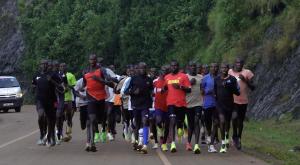 a group of people running a race on a road at Kapto Camp in Kapchorwa