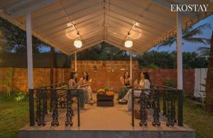 a group of women sitting in a gazebo at EKOSTAY - Serenity Villa in Alibaug