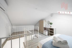 a white room with a bed and a staircase at Azur Apartments by Paralia Living in Nikiti
