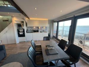 a kitchen and dining room with a table and chairs at Lifeboat House in Skerries