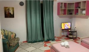 a living room with a couch and a tv at Pinkapartment Saranda in Sarandë