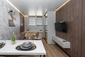 a living room with a table and a tv on a wall at Vilnius City Hotel in Vilnius