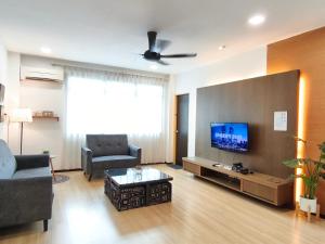 a living room with a couch and a flat screen tv at Eden 8pax 3Rooms apartment near Kuching Airport in Kuching