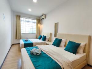 two beds in a room with blue and white at Eden 8pax 3Rooms apartment near Kuching Airport in Kuching