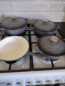 a frying pan on a stove with three pans at Zebra Lodge in Gqeberha