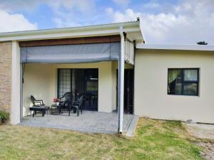 a covered patio with two chairs and a table at Zebra Lodge in Gqeberha