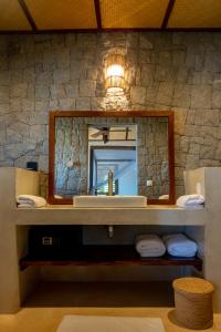 a bathroom with a sink and a mirror at Jardin Vanille in Anjiabe