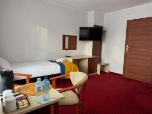 a hotel room with a bed and a table with water bottles on it at Hotel Aleksander in Ustka