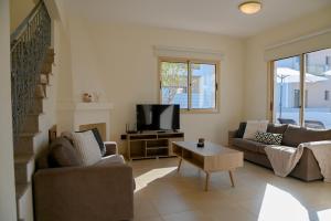 a living room with two couches and a tv at Sorelia Latchi Villas 1- Merope Irena in Polis Chrysochous