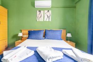 a bedroom with a large bed with blue and green walls at Nehir Apart Hotel in Fethiye