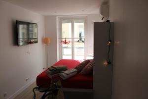 a room with a red couch in front of a window at Rempart du Chateau-SV82 StudioVincennes in Vincennes