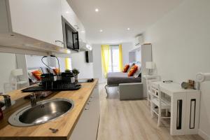 a kitchen with a sink and a living room at Rempart du Chateau-SV82 StudioVincennes in Vincennes