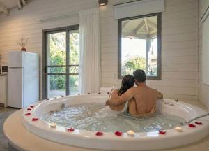 a man and woman sitting in a jacuzzi tub at Nir David Country Lodge in Nir Dawid