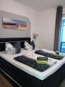 a bed with three pillows on top of it at Westend-Palais in Ahlbeck