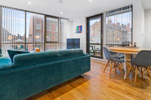 a living room with a green couch and a table at Contractors - Free Parking - City Centre - Balcony - x21 in Hull
