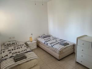 a bedroom with two beds and a dresser at sitbonim in Netanya