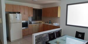 a kitchen with a white refrigerator and wooden cabinets at sitbonim in Netanya