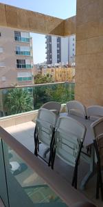 a table and chairs on a balcony with a view of a city at sitbonim in Netanya