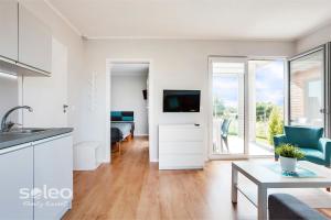 a living room with a kitchen and a bedroom at SOLEO Family Resort - domki w Rewalu 3 min od Morza - 3 Baseny, 5 Jacuzzi, Sauna, ANIMACJE, Małpi Gaj, 3 Sale Zabaw, 4 Place Zabaw, 2 Restauracje in Rewal +76 photos