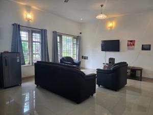 a living room with two couches and a tv at Guru Villa in Yercaud